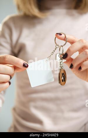 Keychain mockup among olive leaves to display design. Blank white sublimation  key chain photo. Stock Photo