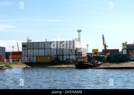 A stack of cargo containers in the docks, Containers at the pier. The concept of storing containers in the port. Stock Photo