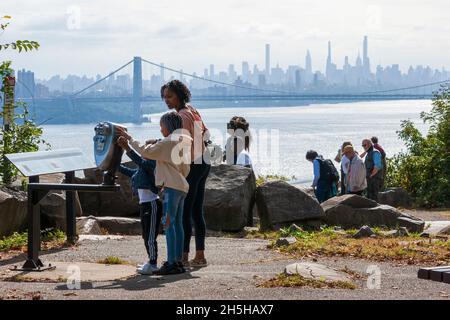 Tourists enjoying the view of the George Washington Bridge and the Manhattan skyline from the Rockefeller Lookout on the Palisades Interstate Parkway. Stock Photo