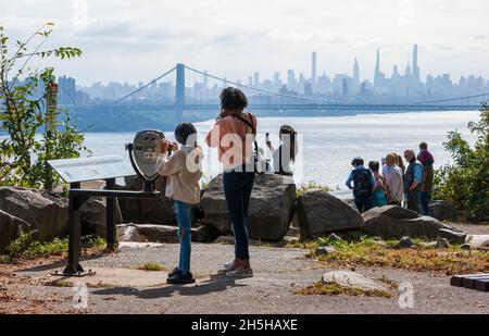 Tourists enjoying the view of the George Washington Bridge and the Manhattan skyline from the Rockefeller Lookout on the Palisades Interstate Parkway. Stock Photo