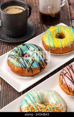Four different donuts with coffee on wooden table Stock Photo