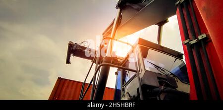 Reach stacker lifting container. Forklift truck handling container at dock. Reach stacker vehicle. Container transport in logistic industry. Cargo Stock Photo