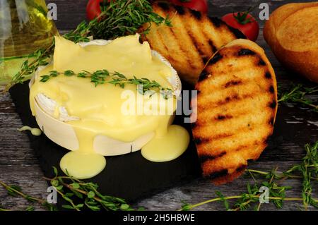 Baked creamy French Camembert cheese with crusty toasted bread Stock Photo