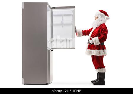 Full length profile shot of a Santa Claus opening an empty fridge isolated on white background Stock Photo