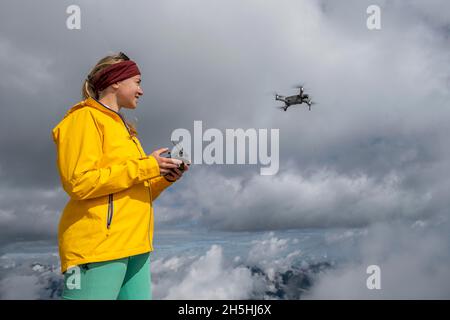 Young woman flying a drone with camera, DJI Mavic Pro, Garmisch Partenkirchen, Bavaria, Germany Stock Photo