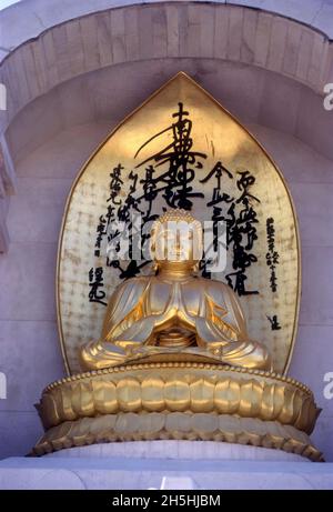 Gilded statue of Buddha on Vishwa Shanti Stupa, Rajgir, Bihar, India Stock Photo