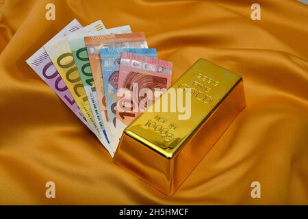 Symbolic picture Protection against inflation, gold bar fine gold fineness 999.9 and money compartments EURO, Baden-Wuerttemberg, Germany Stock Photo