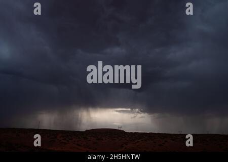 Dramatic sky with storm clouds and rain falling down | Landscape Dark clouds over land pouring down streaks of rain, Stunning view Stock Photo