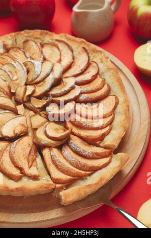 Delicious apple pie on a red backdrop. Freshly baked apple pie with crispy crust, festive homemade sweet pastry Stock Photo