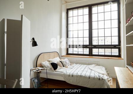 Interior of contemporary bedroom with new comfortable bed and wooden shelves in flat designed in minimal style Stock Photo