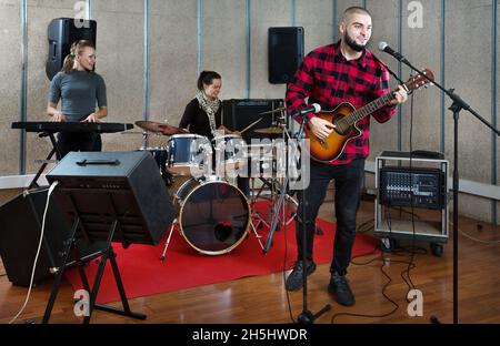 Bearded guy soloist playing guitar in studio Stock Photo