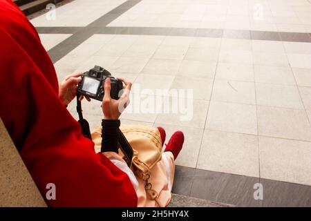 Woman in hijab dress holding a camera Stock Photo