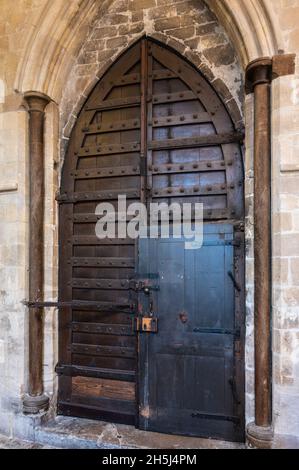 Old wooden door within a door inside Chichester Cathedral in Chichester, West Sussex, UK. With thanks to The Dean & Chapter of Chichester Cathedral. Stock Photo