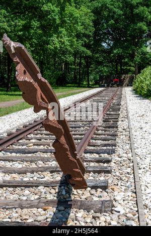 Westerbork, The Netherlands-July 2021; Low angle close up view of broken railroad track torn from ground as monument for deportation of Jews Stock Photo