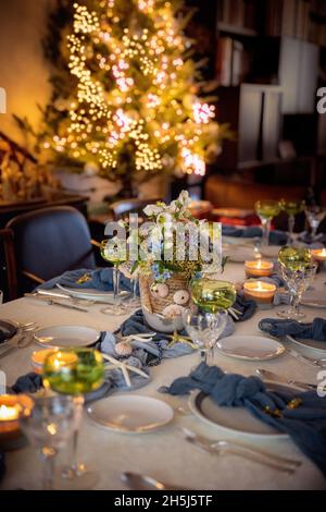 Christmas dinner table decorations in blues and gold following a beach  theme with seashells and starfish Stock Photo - Alamy