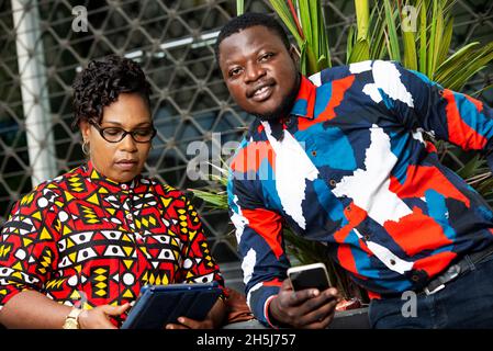 Various coworkers using phone outside. message man and woman on cellphone, using the mobile application online. Stock Photo