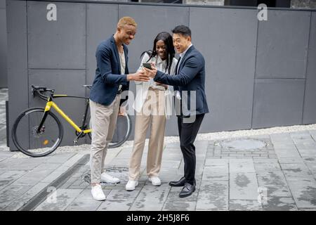Group of business people watching on smartphone Stock Photo