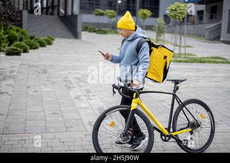 Courier search client place on smartphone in city Stock Photo