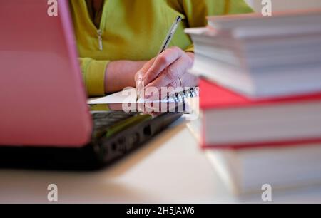 mature female student writing on notepad, norfolk, england Stock Photo