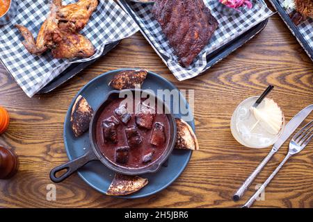 Sheffield UK –  01 May 2018: Sticky BBQ pork, fried chicken, and a rack of ribs – American diner barbecue food from Fire Pit, West Street Stock Photo