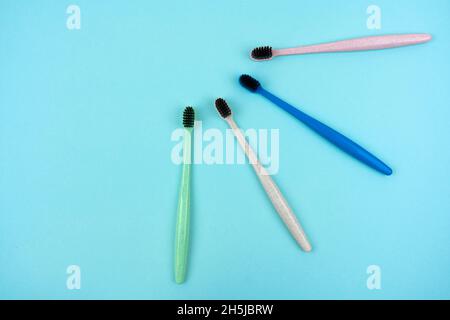 Colored toothbrushes made from recycled plastic on a light blue background with copy space. Top view Stock Photo
