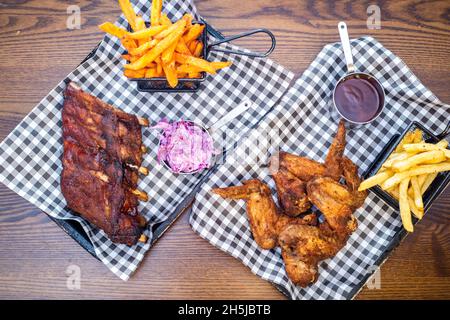 Sheffield UK –  01 May 2018: Rack of ribs and fried chicken and fries – American diner barbecue food from Fire Pit, West Street Stock Photo