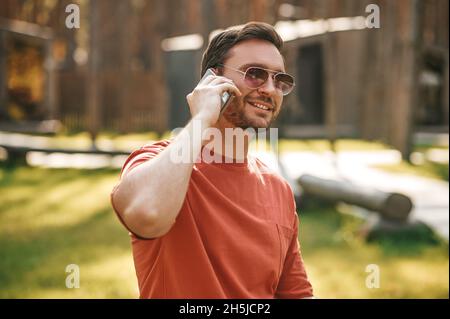 Attractive young adult man communicating by smartphone Stock Photo