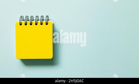 Yellow note pad isolated on blue background. top view, copy space Stock Photo