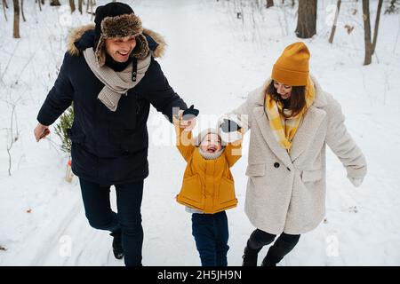 The family has fun walking through the winter forest on Christmas Eve Stock Photo