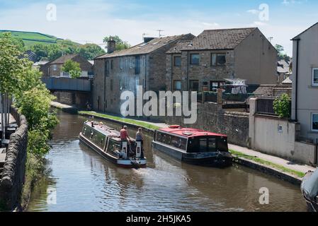 Leeds Liverpool Canal, view in summer of a narrow boat cruising the Leeds And Liverpool Canal, leaving the town of Skipton, North Yorkshire UK Stock Photo