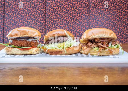 Sheffield UK –  22 May 2018: Classic Cheeseburger, pulled pork burger and chicken burger – American diner food from Fire Pit, West Street Stock Photo