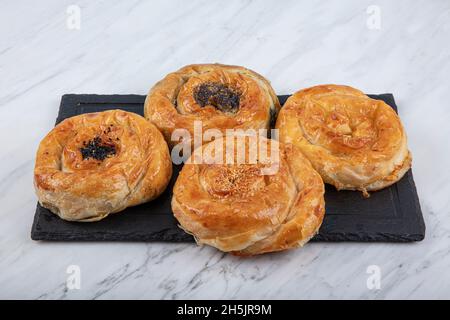 Homemade turkish acma with nigella seeds. Freshly backed swirl buns. With cheese, with potatoes acma, with spinach acma, with minced meat acma. Stock Photo