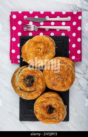 Homemade turkish acma with nigella seeds. Freshly backed swirl buns. With cheese, with potatoes acma, with spinach acma, with minced meat acma. Stock Photo