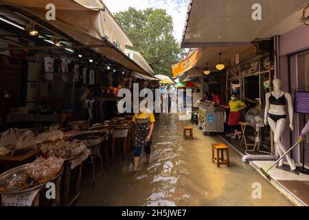 A woman walks through a flooded street in Wang Lang Market.Chao Phraya River is overflowing influenced from heavy rainfall causing flooding in Wang Lang Market and many low lying areas along Chao Phraya River. (Photo by Phobthum Yingpaiboonsuk / SOPA Images/Sipa USA) Stock Photo