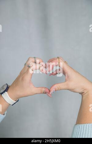 Women's hands with beautiful manicure and rings are folded in a beautiful gentle elegant gesture Stock Photo