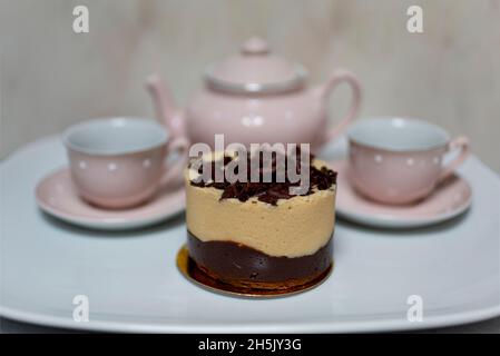 Tea party, with tea pot,tea cups and gourmet mini cake; Studio Shot Stock Photo