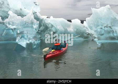 A kayak paddler passes sculpted icebergs in Tracy Arm Fjord. Stock Photo