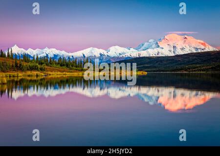 Sunset glow on Mount Denali (McKinley) reflects on Wonder Lake with pastel sky, Denali National Park and Preserve in autumn, Interior Alaska Stock Photo