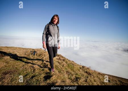 Puy de Dome, France on november 09, 2021, A woman walks at the top of Puy de Dome, in front of her a sea of clouds covering the city of Clermont-Ferrand, Puy de Dome, France on november 09, 2021.Illustration photograph of the Puy de Dome emblematic mountain of the Auvergne region. Photo by Thibaut Durand /ABACAPRESS.COM Stock Photo