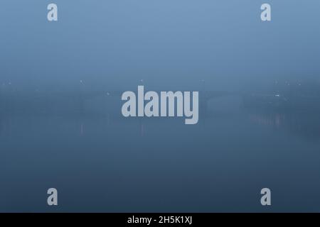 View of bridge in the fog in the early morning with silhouettes. Prague, Czech Republic.
