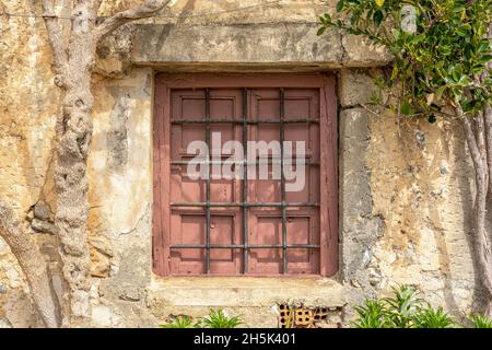 Old wooden window on stone wall in Rethymnon. Greece. Stock Photo