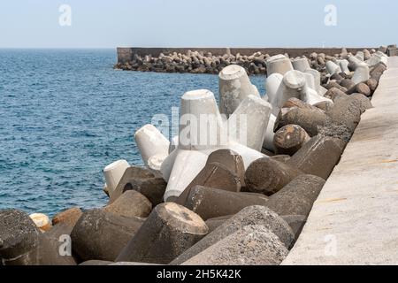 Breakwater protection under blue sky, solid concrete blocks in port of Heraklion. Greece. Stock Photo