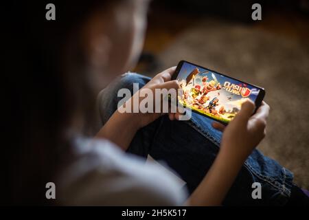 Bucharest, ROMANIA - May 10, 2021: Illustrative editorial concept image of a child playing Clash of Clans game on a mobile phone. Stock Photo
