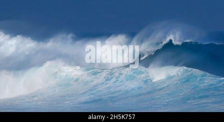 White water froth of large, breaking waves crashing in the ocean with a dark sky; Hawaii, United States of America Stock Photo