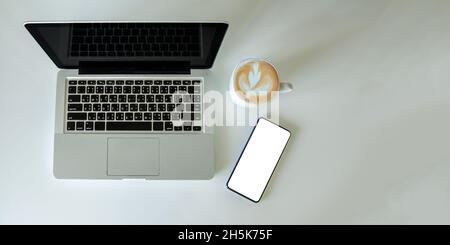 Top view mock up smartphone with mouse computer laptop and coffee cup.Copy space flat lay. Stock Photo