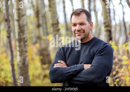 A portrait of a mature man in a city park on a warm fall afternoon; St. Albert, Alberta, Canada Stock Photo
