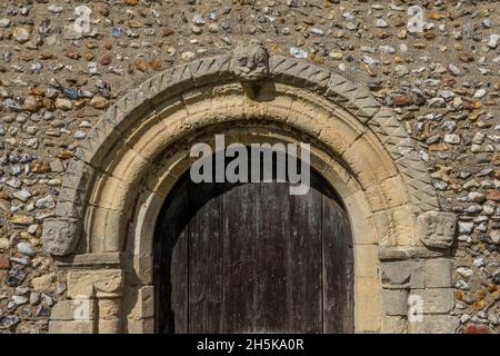 Top half of Norman arch over wooden doorway, St John the Baptist's Church, Wantisden, Suffolk, UK Stock Photo