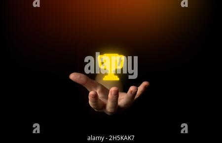 Leadership successful achievement with goal and objective target. World win concept. Hand and trophy on a black background photo Stock Photo