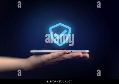 Data protection, privacy information. Hand holding mobile phone with shield. Cyber security network, internet technology concept Stock Photo