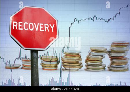 Recovery stop road sign on economy background with graph and coins. Economy recovery concept. Stock Photo
